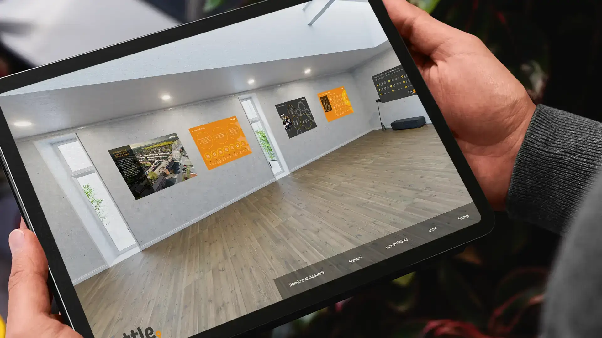 A tablet screen showing a static image of a 3D virtual exhibition space.