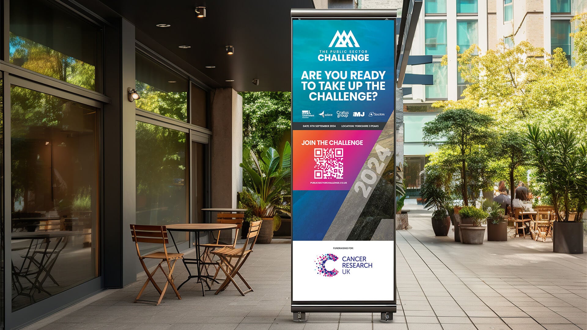 Roll-up banner for the Public Sector Challenge outside an office, asking if people are ready to take up the challenge, with the Cancer Research UK logo