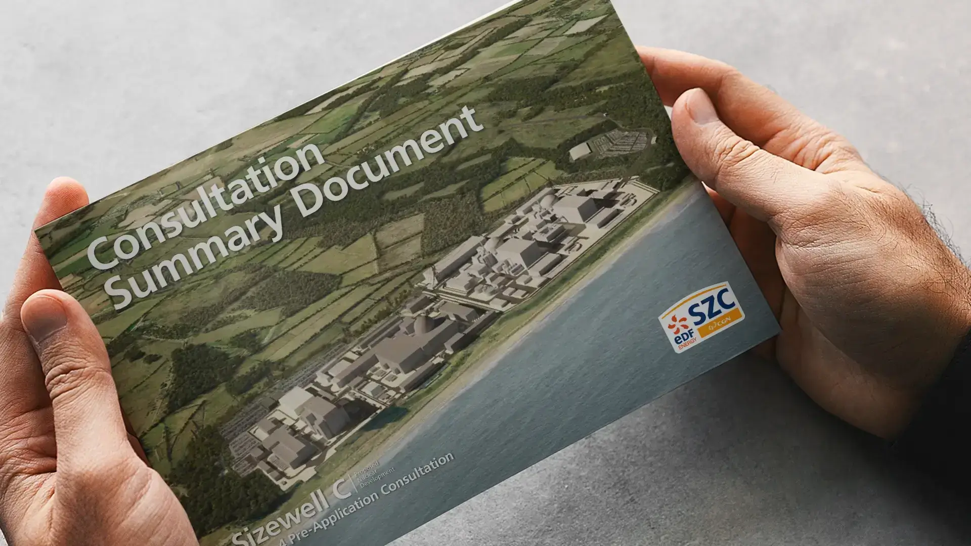 A set of hands holding a printed consultation booklet designed for EDF Energy